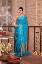 KAVVYA SOFT & LIGHT WEIGHT SKY BLUE CRAPE SAREE WITH SATIN BORDER AND BEAUTIFIL SILK ZARI WEAVING BORDER AND SMALL FLAMINGO MOTIFS ALL OVER THE SAREE COMES WITH SAME COLOUR WEAVED BLOUSE