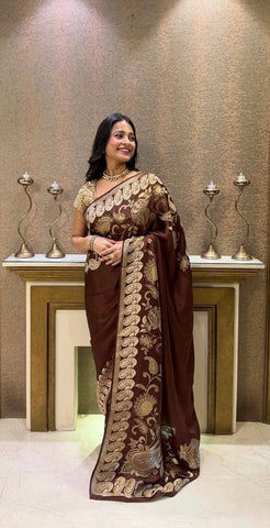 Premium brown saree adorned with intricate gold floral patterns.